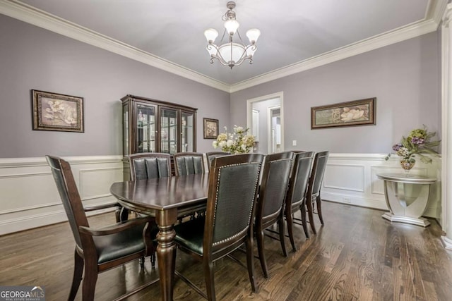 dining room featuring an inviting chandelier, ornamental molding, and dark wood finished floors