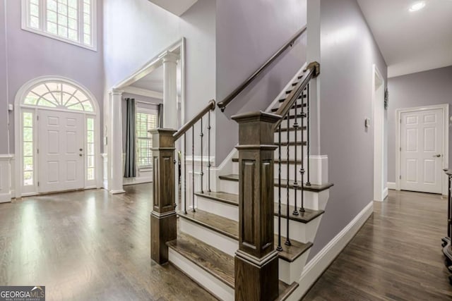 foyer with baseboards, stairs, and wood finished floors
