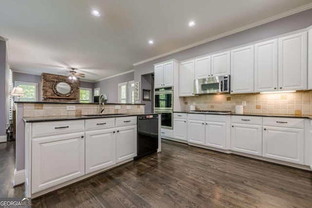 kitchen with a ceiling fan, dark countertops, dark wood finished floors, a sink, and stainless steel appliances
