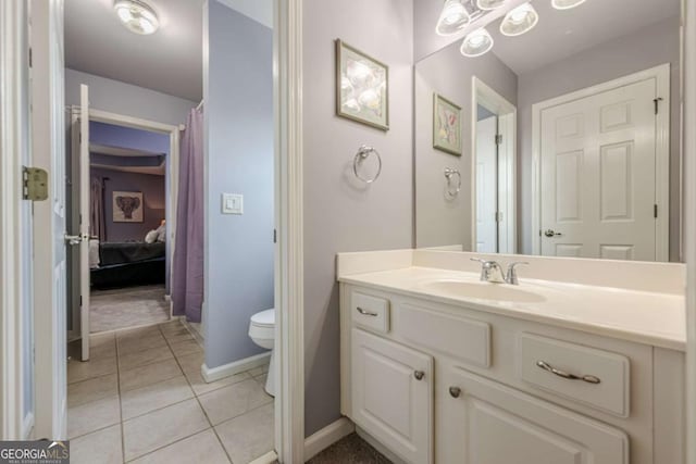 bathroom with vanity, tile patterned floors, baseboards, and toilet