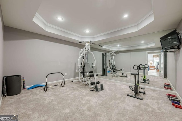 exercise area featuring a raised ceiling, carpet floors, recessed lighting, baseboards, and ornamental molding