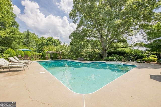 pool with a patio and a pergola