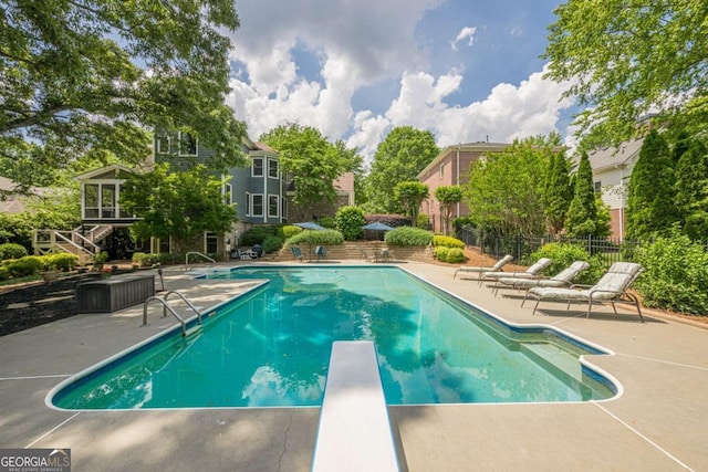 view of pool with fence, a fenced in pool, a patio, and a diving board