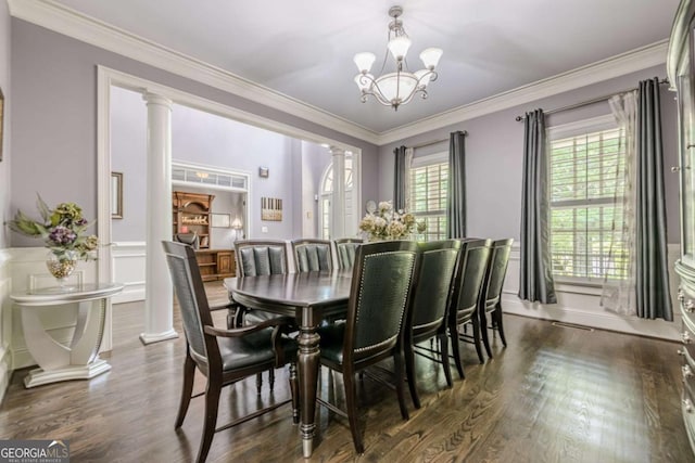 dining room featuring crown molding, decorative columns, an inviting chandelier, and dark wood-style floors