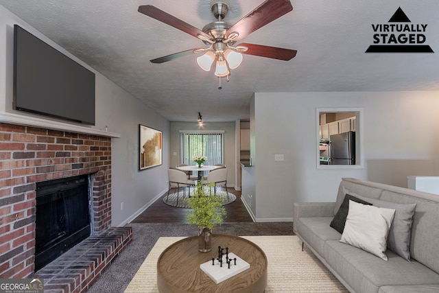 5723 Fieldstone Dr, Lithonia, GA 30038 - carpeted living room with baseboards, a fireplace, ceiling fan, and a textured ceiling