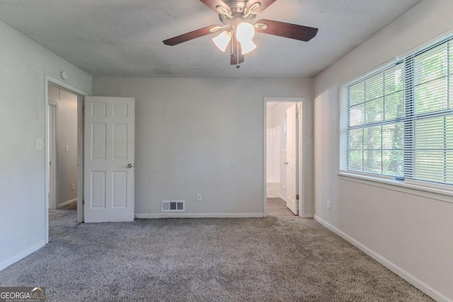 5723 Fieldstone Dr, Lithonia, GA 30038 - unfurnished bedroom with carpet, baseboards, ensuite bathroom, ceiling fan, and visible vents