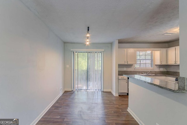 5723 Fieldstone Dr, Lithonia, GA 30038 - kitchen featuring white cabinets, a textured ceiling, dark wood-type flooring, and dark stone counters