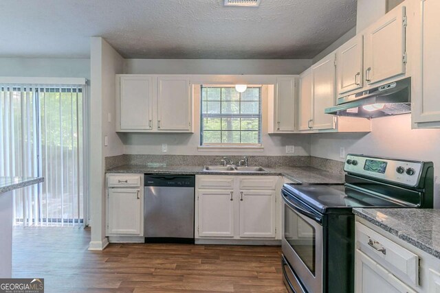 5723 Fieldstone Dr, Lithonia, GA 30038 - kitchen with under cabinet range hood, dark wood-style flooring, a sink, stainless steel appliances, and white cabinets