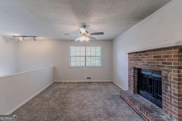 5723 Fieldstone Dr, Lithonia, GA 30038 - unfurnished living room with a textured ceiling, visible vents, a fireplace, ceiling fan, and carpet flooring