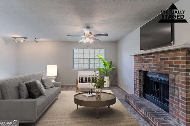 5723 Fieldstone Dr, Lithonia, GA 30038 - living room featuring carpet, a brick fireplace, ceiling fan, and a textured ceiling