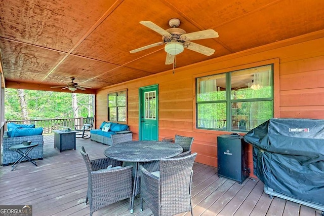 deck with a ceiling fan, outdoor dining space, an outdoor hangout area, and area for grilling