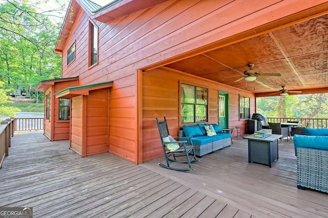 wooden deck with a ceiling fan and outdoor lounge area