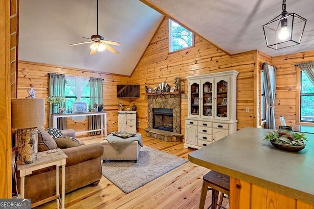 428 Gibbs Rd, Blairsville, GA 30512 - living area featuring wood walls, wood-type flooring, ceiling fan, a fireplace, and high vaulted ceiling
