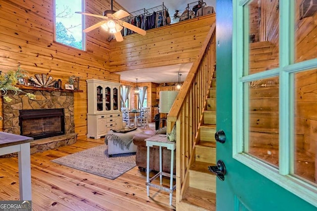 428 Gibbs Rd, Blairsville, GA 30512 - living room featuring wood walls, ceiling fan, stairs, a high ceiling, and wood finished floors
