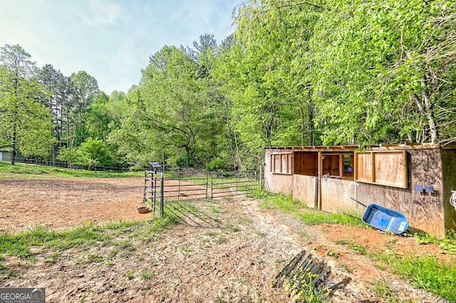 exterior space with an exterior structure, a wooded view, and an outdoor structure