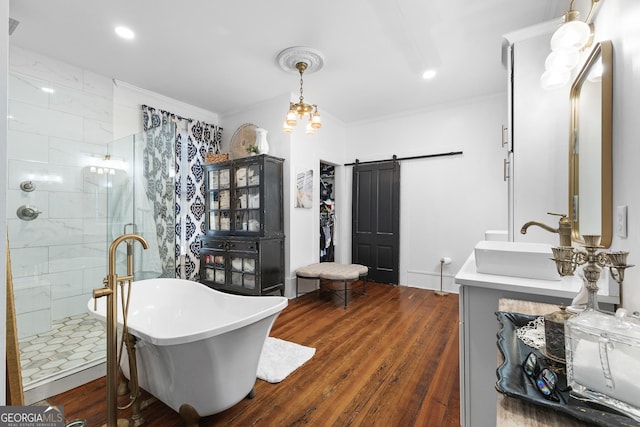 full bath with crown molding, wood finished floors, vanity, a soaking tub, and tiled shower