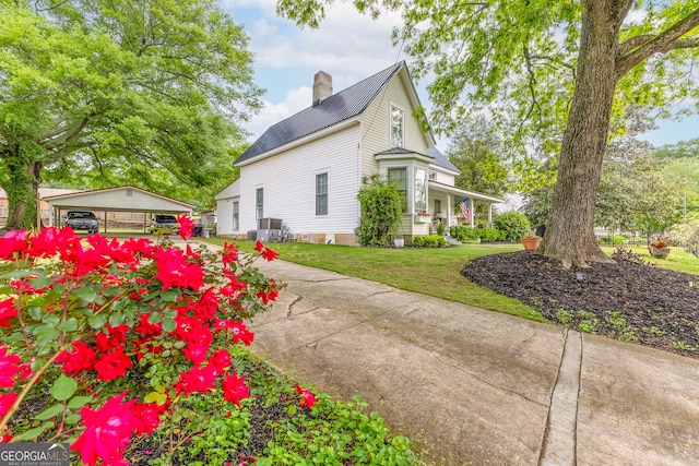 view of home's exterior featuring a yard, a chimney, and central air condition unit