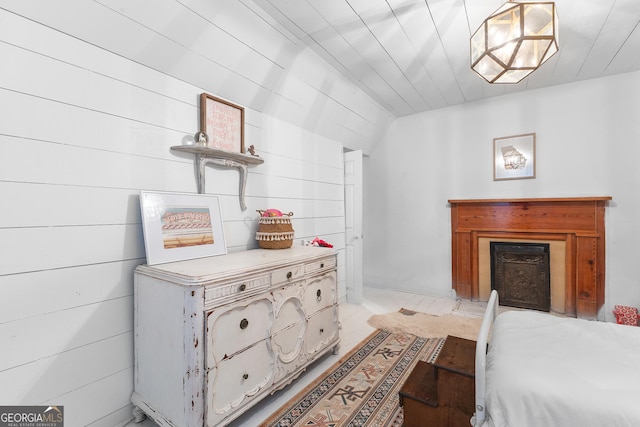bedroom with vaulted ceiling and a fireplace