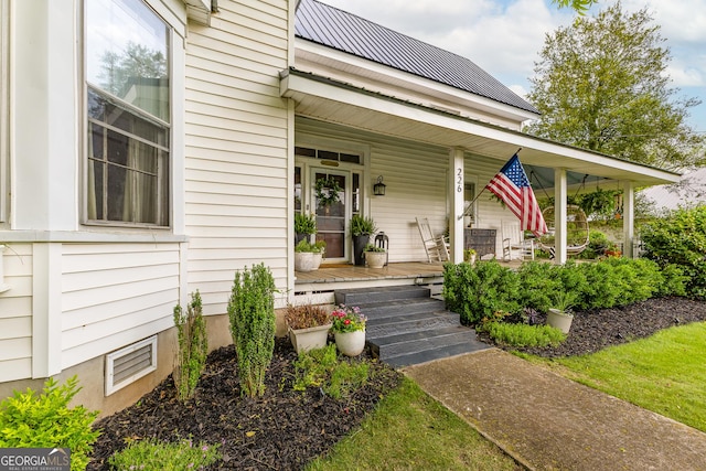 property entrance featuring a porch and metal roof