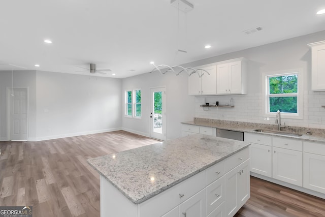 kitchen featuring a sink, ceiling fan, stainless steel dishwasher, decorative backsplash, and healthy amount of natural light