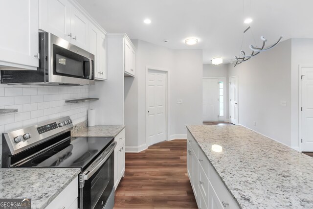 kitchen featuring appliances with stainless steel finishes, dark wood-type flooring, decorative backsplash, white cabinetry, and recessed lighting