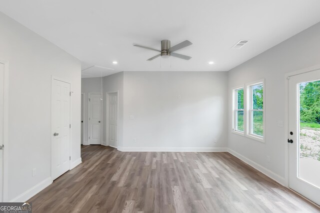 unfurnished room featuring attic access, ceiling fan, wood finished floors, baseboards, and recessed lighting