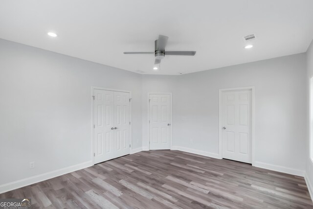 unfurnished bedroom with wood finished floors, baseboards, recessed lighting, and a ceiling fan