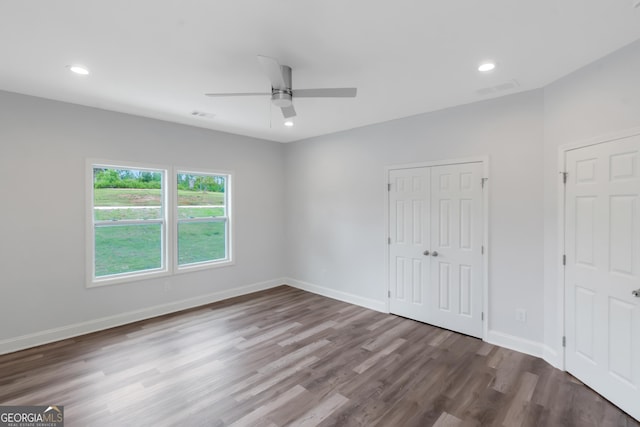 unfurnished bedroom with wood finished floors, baseboards, recessed lighting, a closet, and ceiling fan