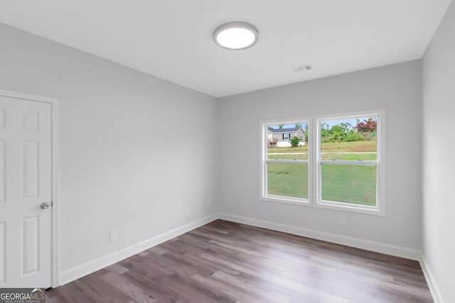 empty room with wood finished floors and baseboards