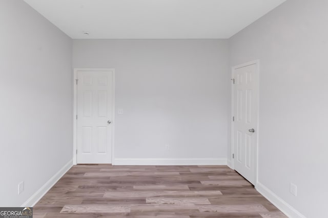 empty room featuring wood finished floors and baseboards