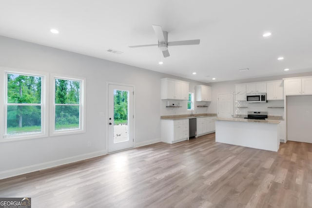 kitchen featuring stainless steel appliances, a ceiling fan, light countertops, light wood-style flooring, and white cabinetry