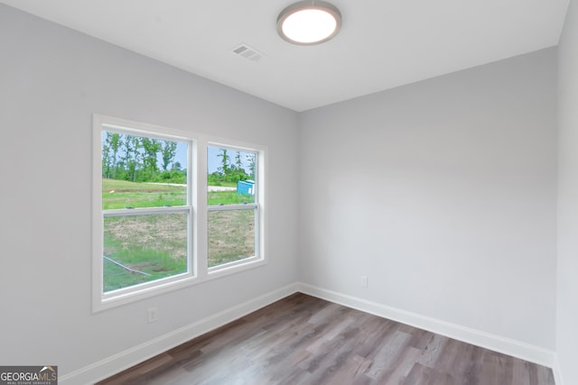 unfurnished room featuring baseboards and wood finished floors