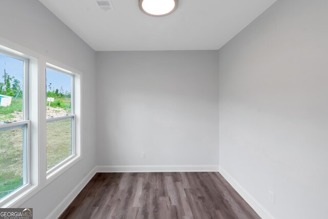 unfurnished room with dark wood-style floors and baseboards