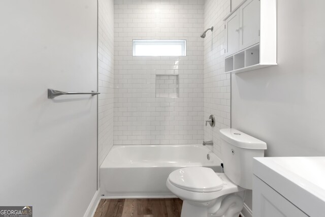 bathroom featuring toilet, tub / shower combination, wood finished floors, vanity, and baseboards