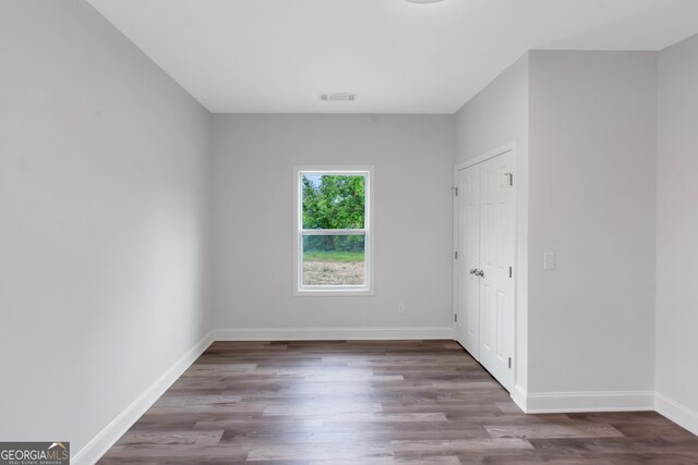 unfurnished bedroom with wood finished floors and baseboards