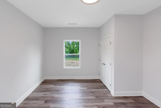 unfurnished bedroom with wood finished floors and baseboards