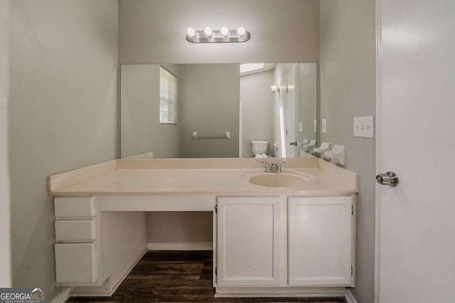 bathroom with toilet, wood finished floors, and vanity
