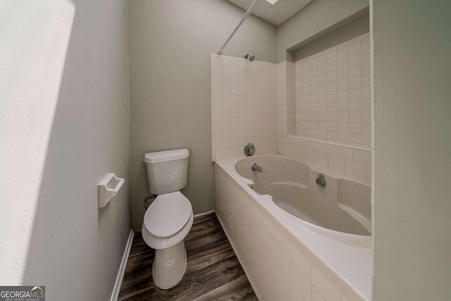 bathroom with toilet, bathtub / shower combination, and wood finished floors