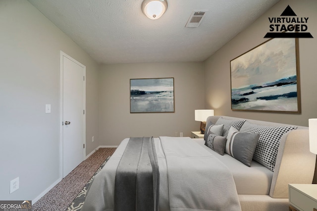 carpeted bedroom featuring a textured ceiling, baseboards, and visible vents
