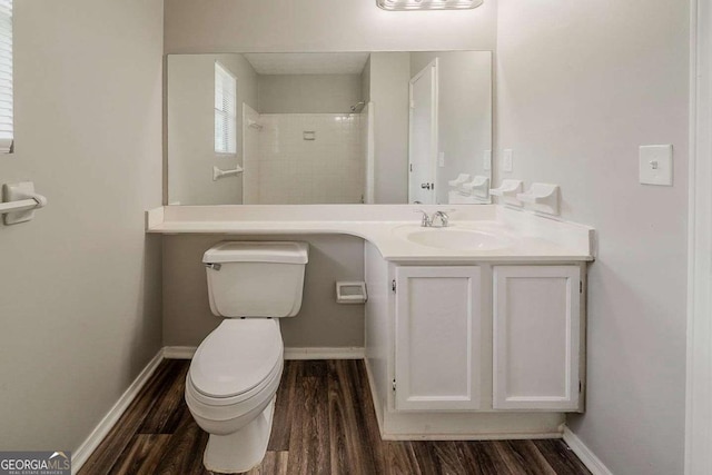 bathroom with toilet, vanity, and wood finished floors