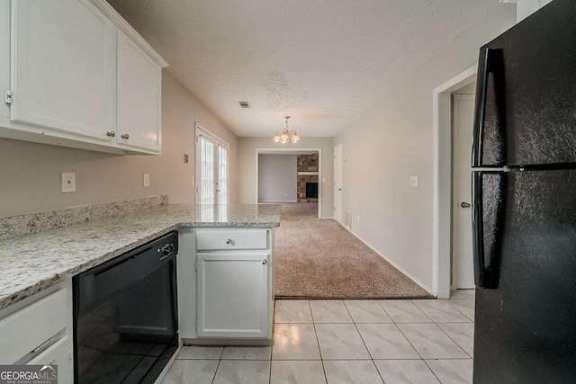 kitchen with a peninsula, a notable chandelier, white cabinets, black appliances, and light carpet