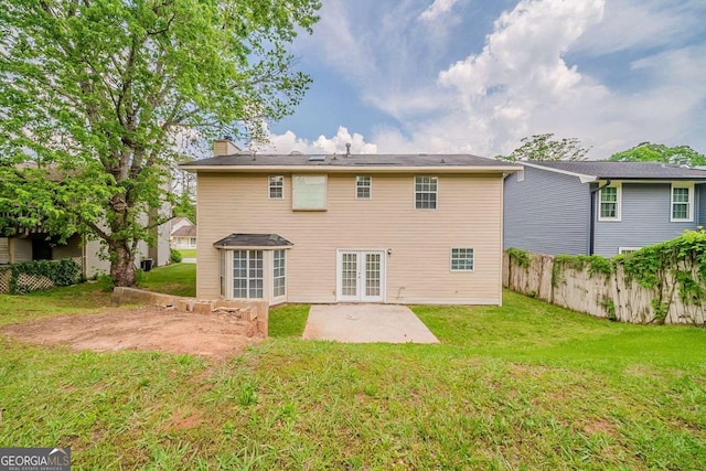 back of property with a chimney, a lawn, french doors, fence, and a patio