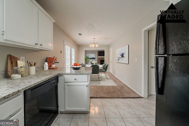 kitchen with a peninsula, black appliances, light carpet, white cabinets, and a notable chandelier
