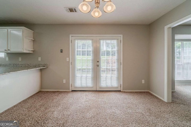 6351 Stablewood Way, Lithonia, GA 30058 - unfurnished dining area featuring light carpet, french doors, and a chandelier