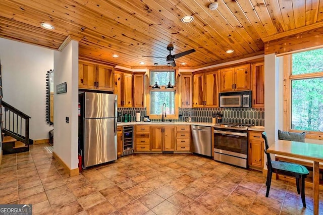kitchen with light countertops, stainless steel appliances, recessed lighting, and beverage cooler