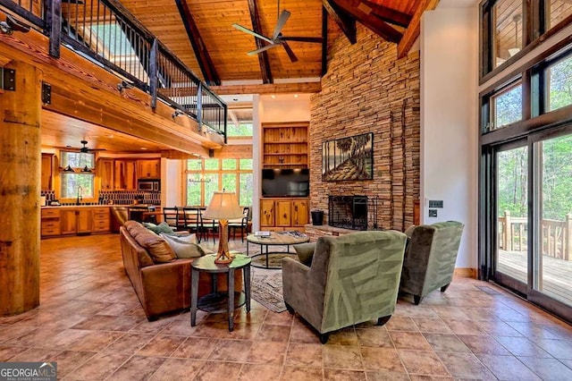 living area featuring plenty of natural light, wood ceiling, ceiling fan, and high vaulted ceiling