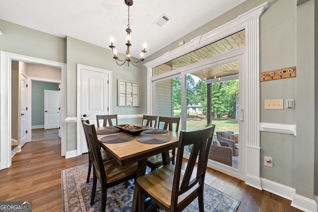 dining area with baseboards, a chandelier, and dark wood finished floors