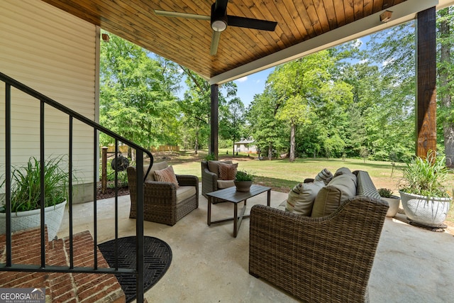 view of patio / terrace featuring a ceiling fan, an outdoor hangout area, and view of wooded area