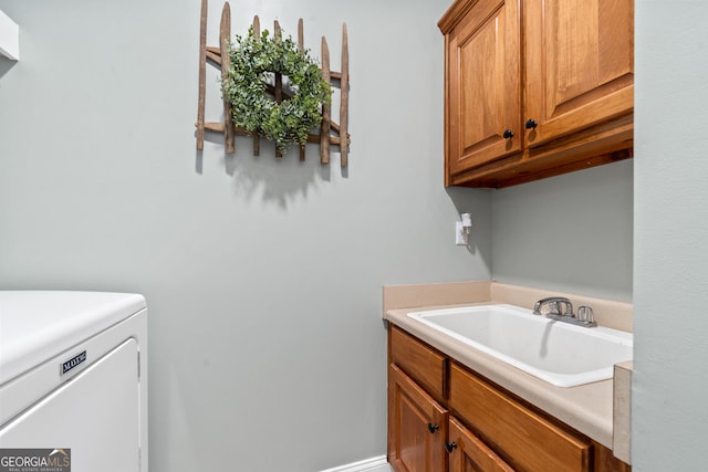 clothes washing area with washer / dryer and cabinet space