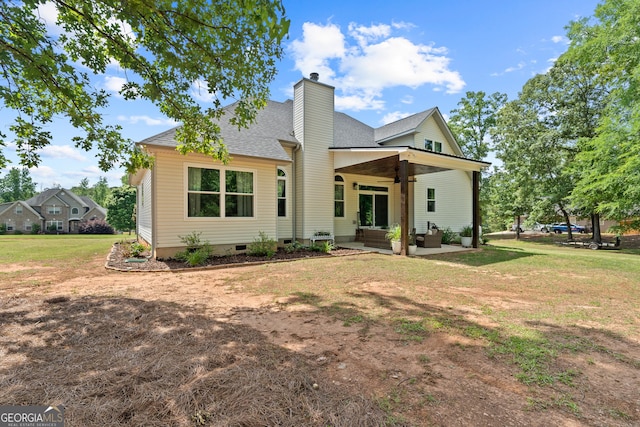 view of front of home featuring a patio, a chimney, roof with shingles, a front lawn, and crawl space